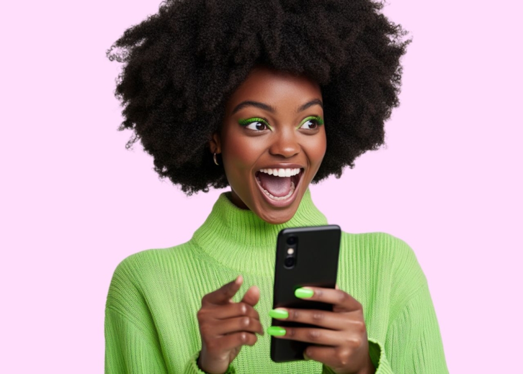 girl in green sweater with green eyeshadow and manicure holding phone in hands on pink background