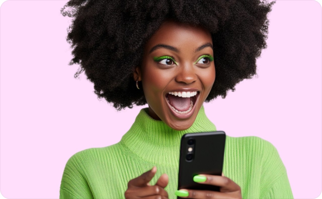 girl in green sweater with green eyeshadow and manicure holding phone in hands on pink background
