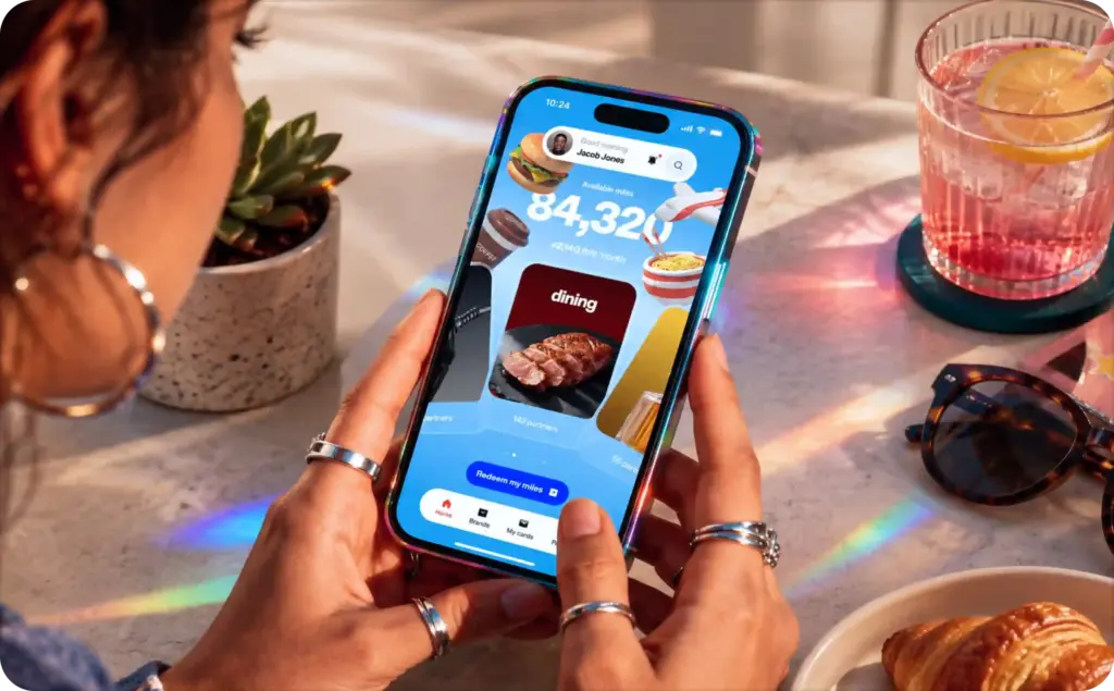 Person using a smartphone to browse an airline rewards app featuring in-app ad formats, including branded dining offers, reward points, and promotional content displayed within the mobile app interface.