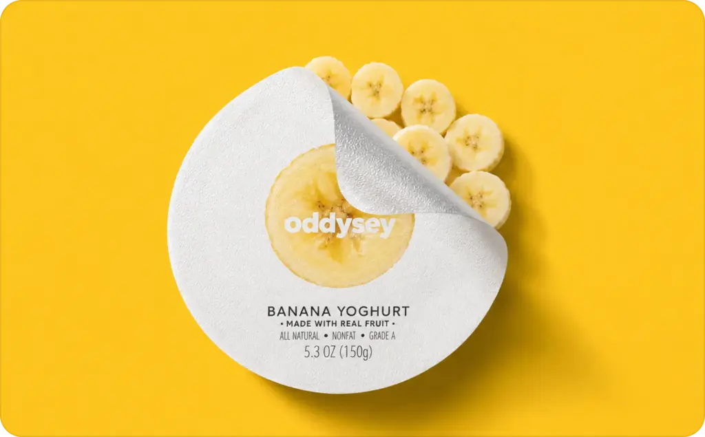 Minimal banana yoghurt packaging mockup on a bright yellow background featuring a peeled white foil lid, a round banana with the Oddysey logo in the center, and fresh banana slices underneath. Inspired by Nano Banana prompts, this clean product-style composition highlights banana yoghurt with a bold, modern aesthetic.